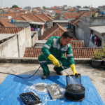 Teknisi AC sedang mencuci dan membersihkan unit AC